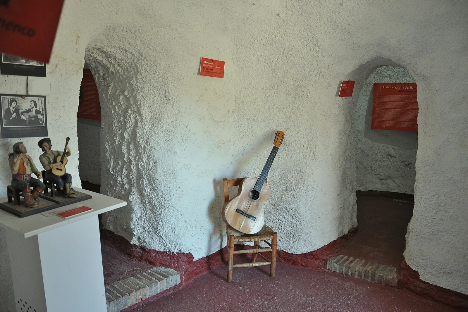 Sacromonte Mağaraları Müzesi'ndeki kubbeli badanalı mağara odasında ahşap bir sandalyede duran gitar